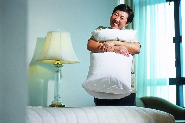 housekeeper with pillow at Frasers Hospitality property