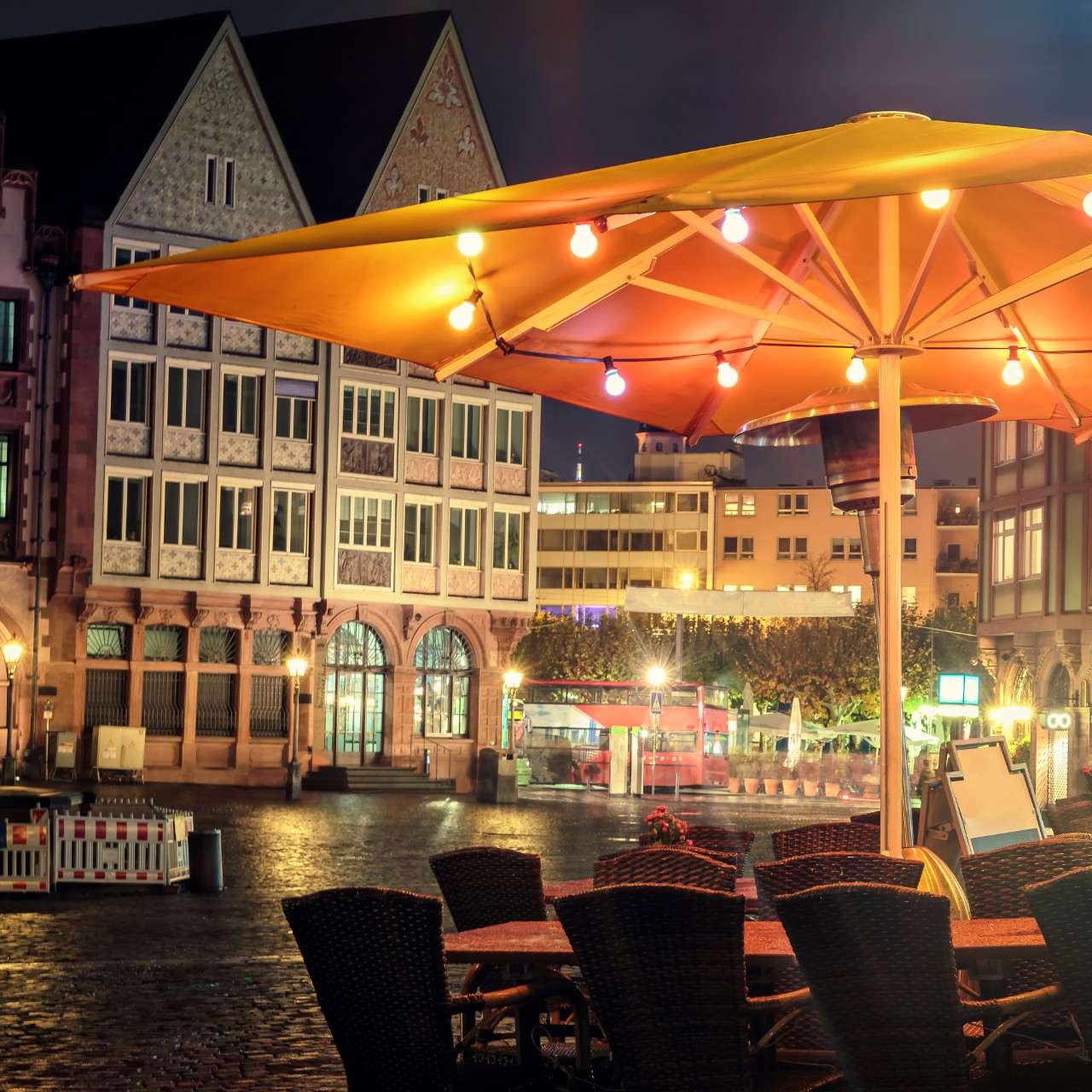 Table and chairs at Romerberg square in Frankfut am Main at dusk