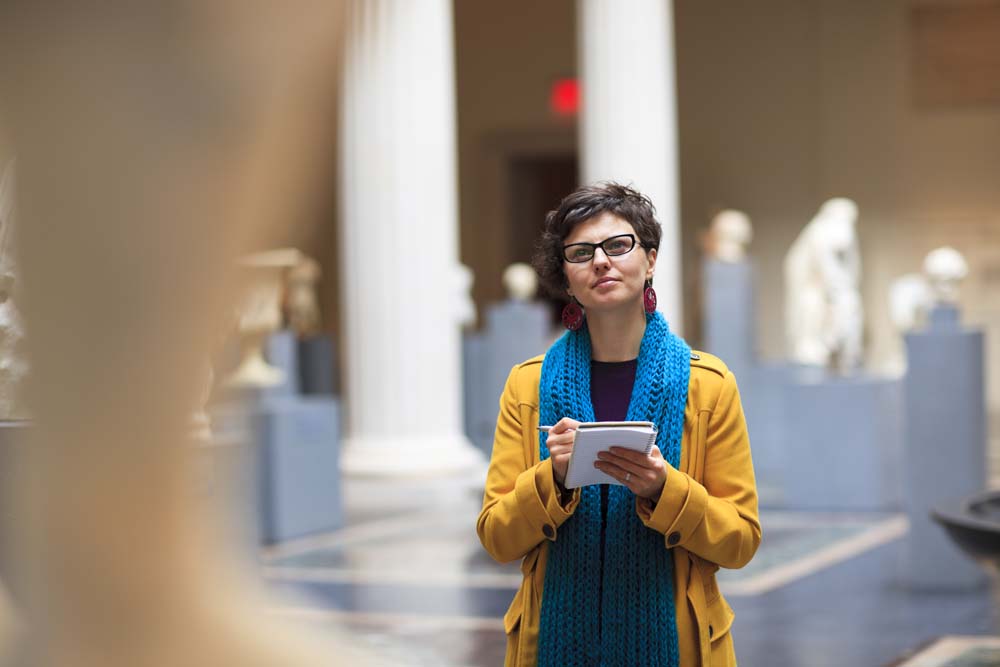 Woman in museum takes notes as she is looking at fine art statue.***PLEASE TAKE YOUR TIME TO TELL ME WHERE MY IMAGE WAS USED***