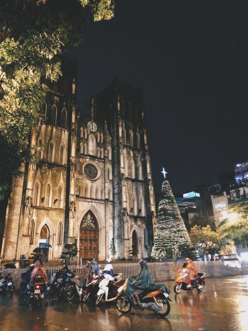 Motorbikes driving by St Joseph's Cathedral in Hanoi, Vietnam