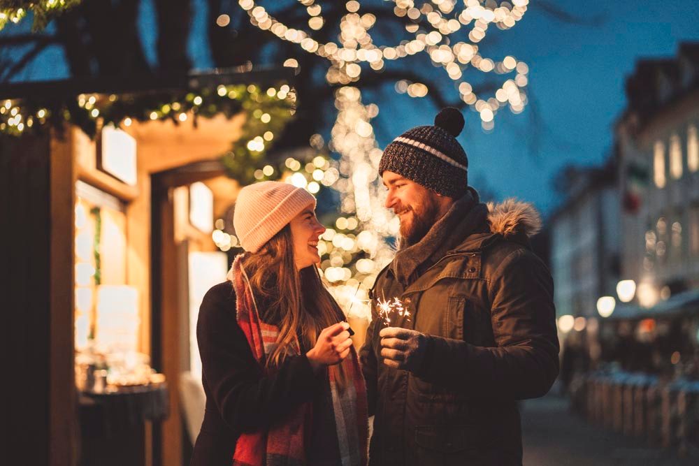Couple enjoy French cuisine at Christmas market in Paris in winter