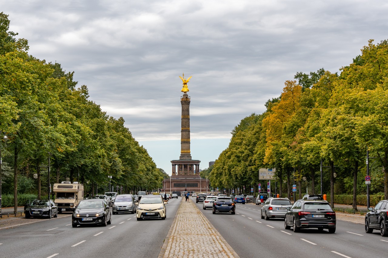 The tall, golden-coloured monument stands in the middle of a busy street in Berlin