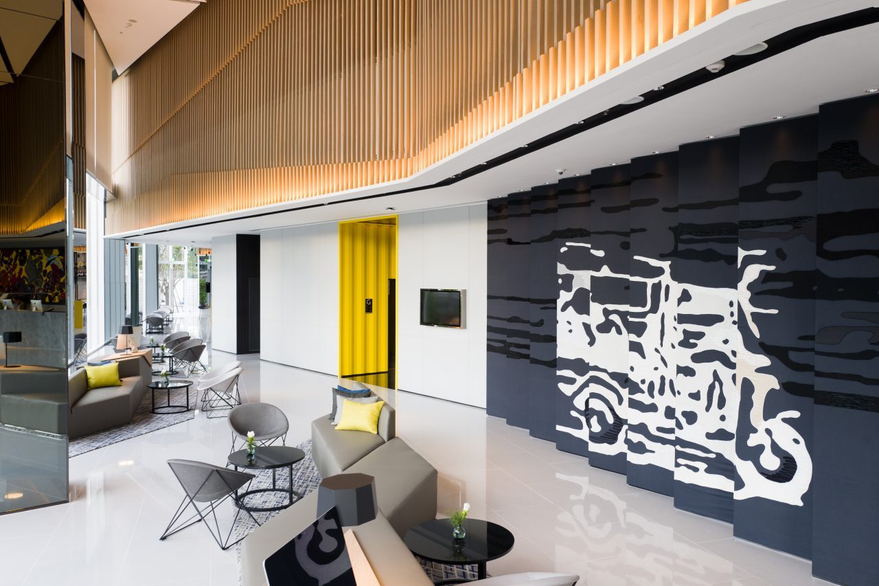 Modena by Fraser Bangkok lobby with tuk-tuk wall art and stylish seating