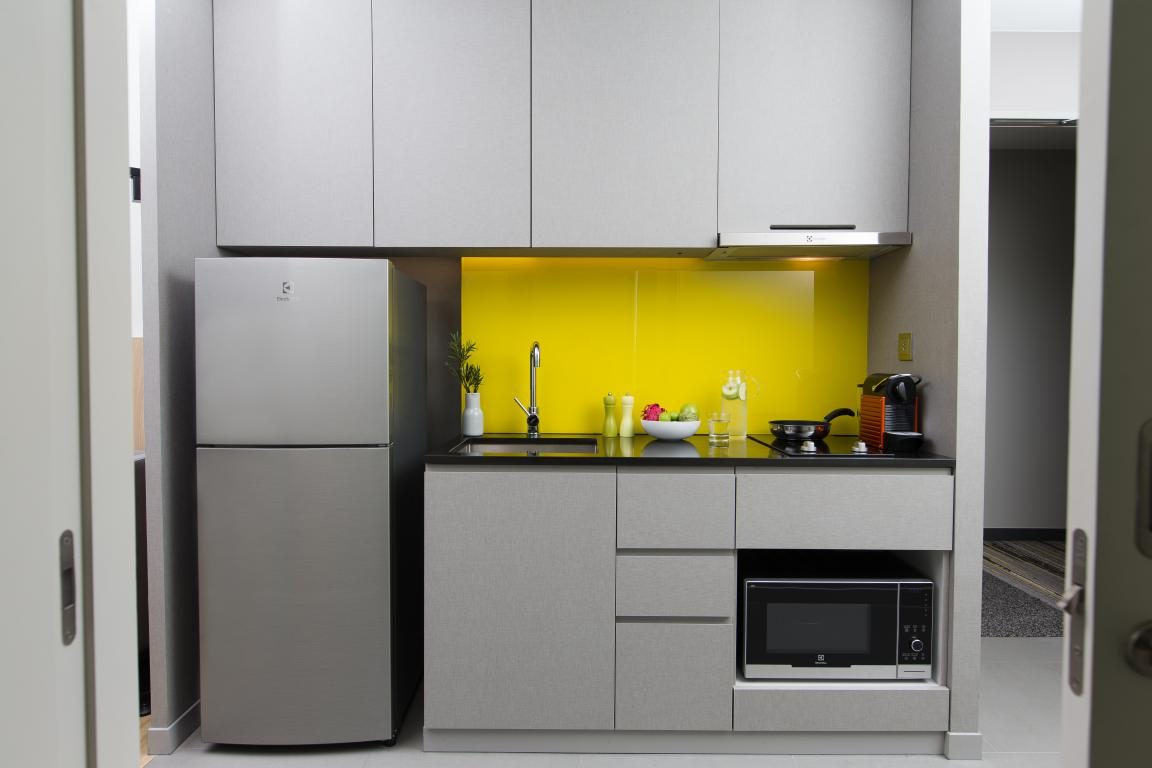 Modern kitchenette with cooking facilities in a serviced apartment in Bangkok
