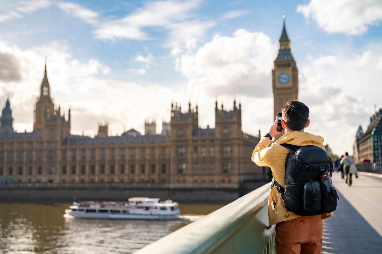 young Latin man tourist against Big Ben and clock tower barrier in London